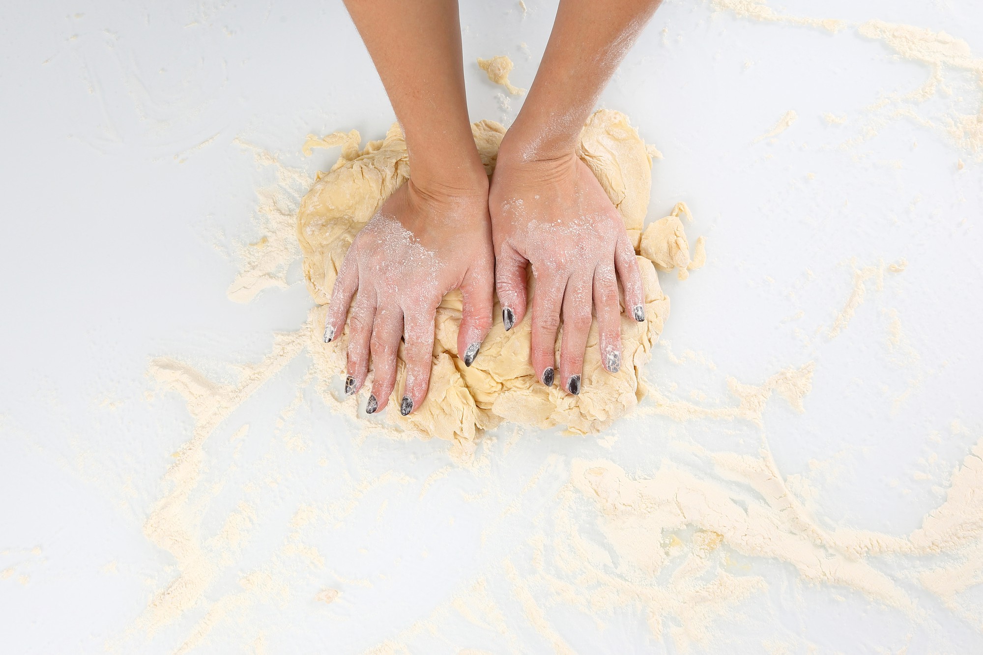 Mani che impastano pasta fresca